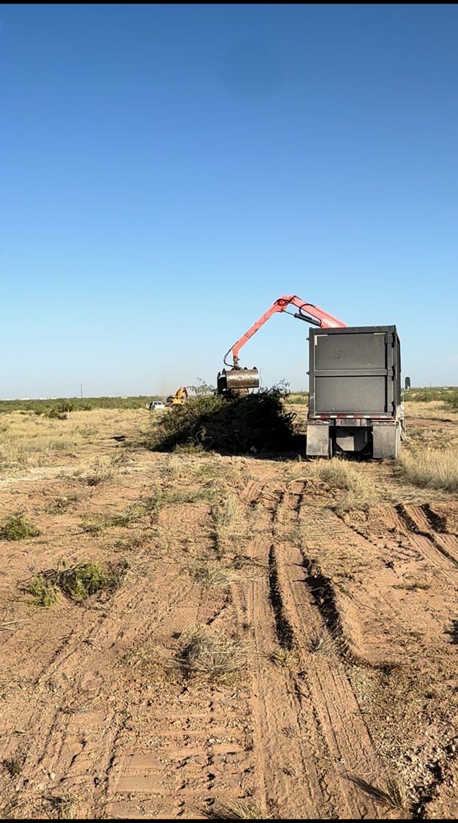 Grapple truck loading cleared brush in West Texas